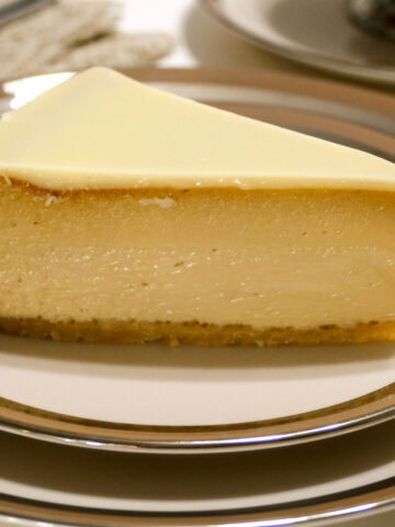 A slice of the White Chocolate Mocha Cheesecake sits on a china plate.