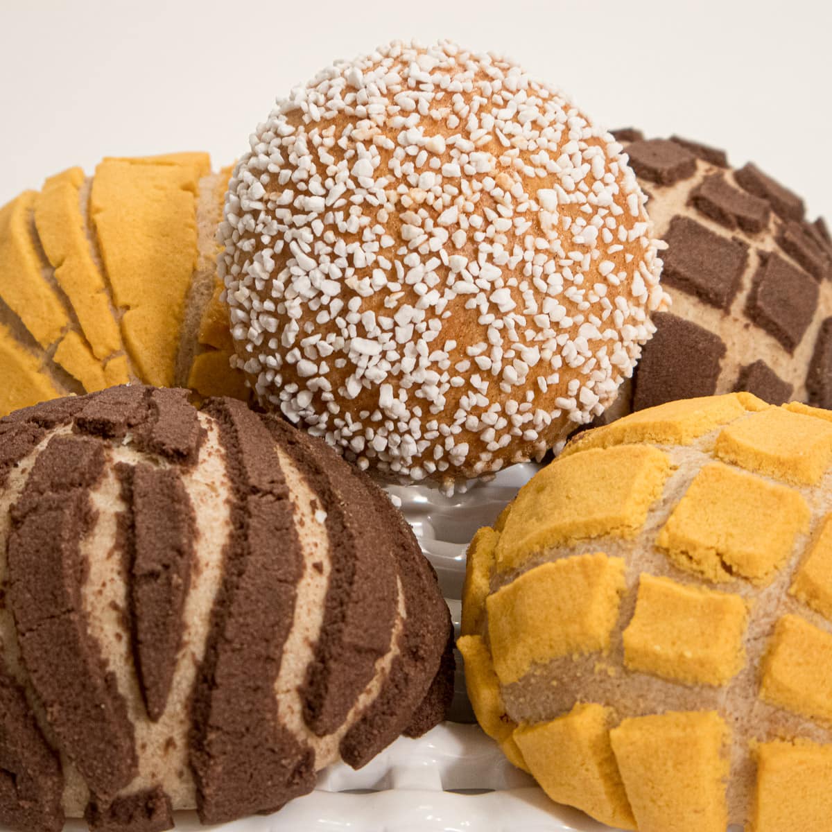 Five Mexican sweet rolls, Conchas with different toppings.