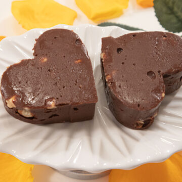 Nutella Hazelnut Fudge Hearts on a white plate with yellow rose petals below.
