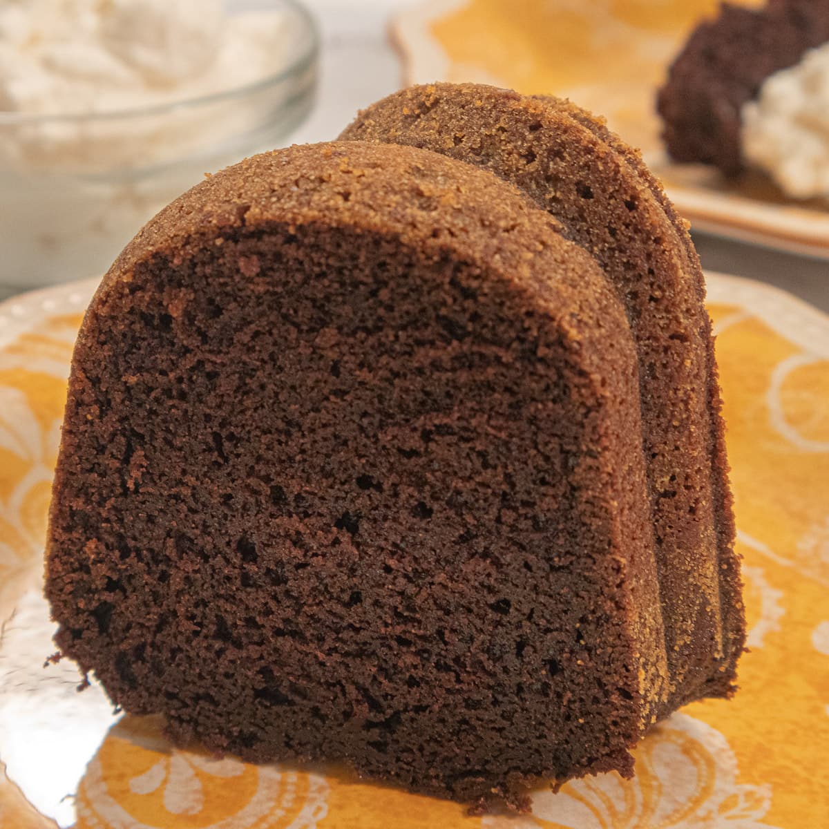 A slice of Guinness Cake sits on a gold and white plate.