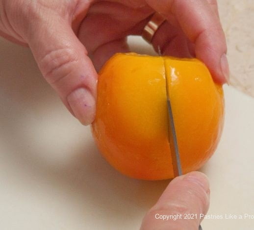 Cutting the peach from top to bottom