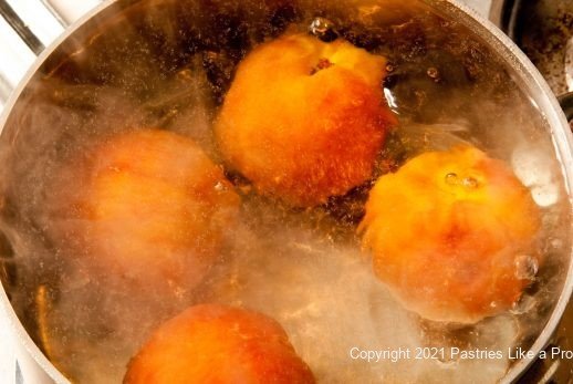 Peaches submerged in boiling water