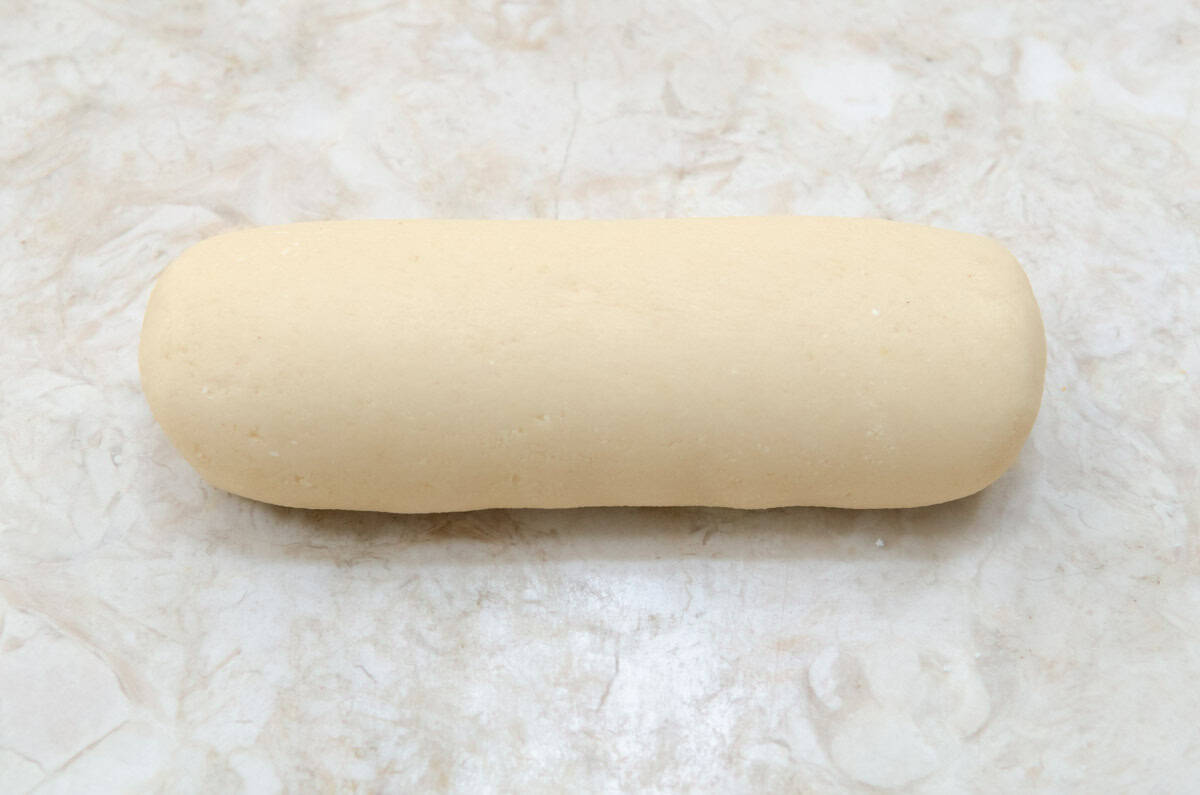 This photo shows a roll of freshly made almond paste.