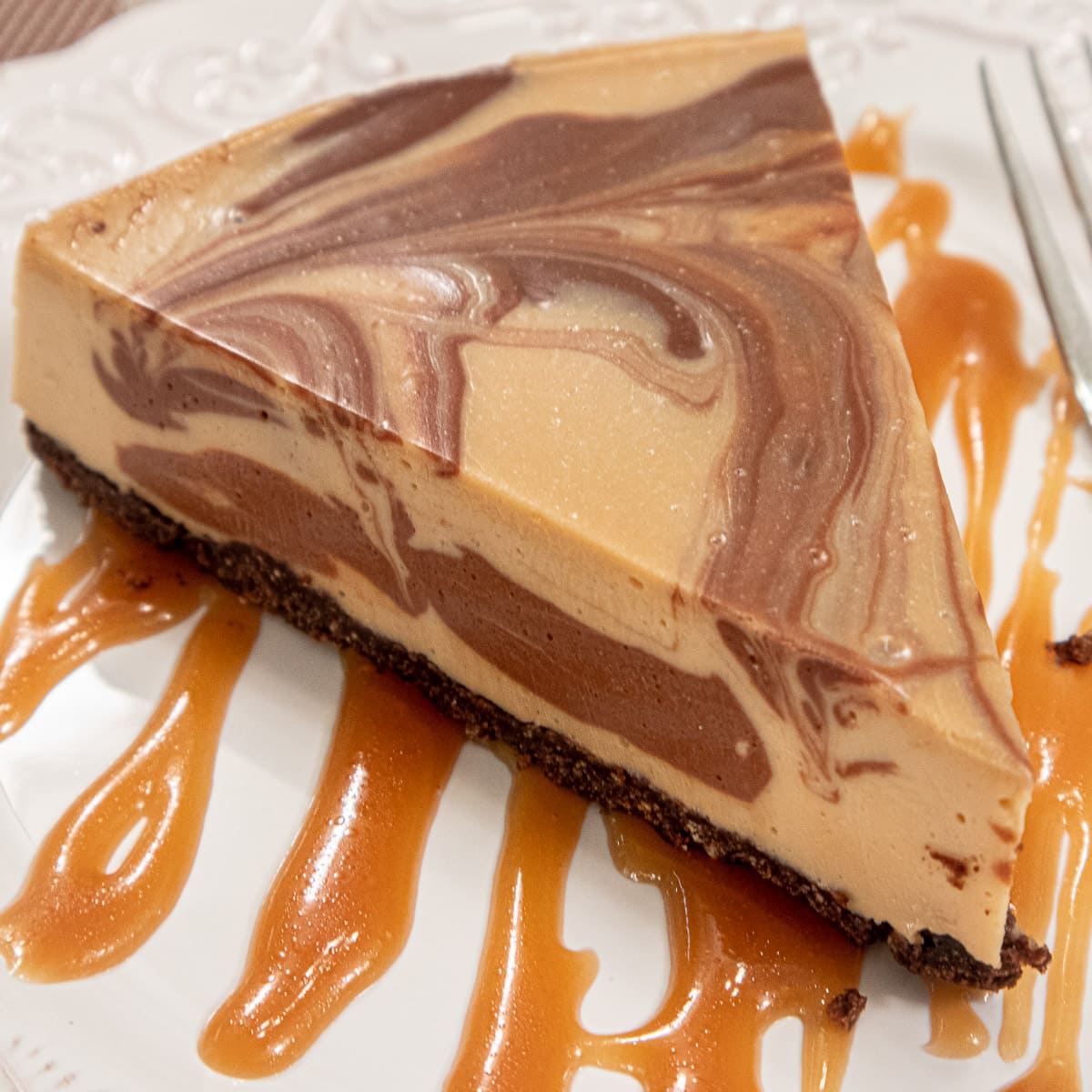 This Chocolate Coffee No Bake Cheesecake sits on a drizzle of caramel sauce