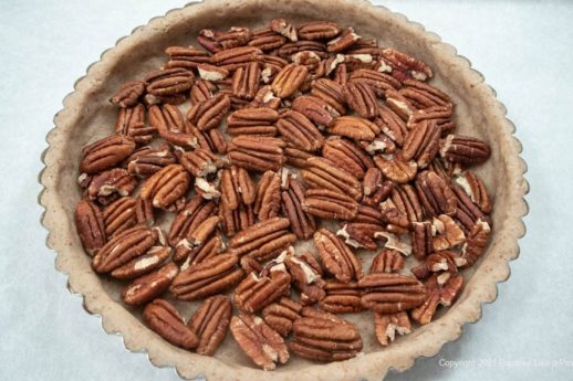 Pecan  halves are covering the bottom of the crust.