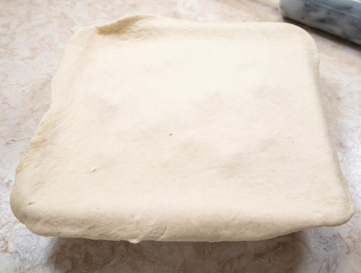 Top dough draped over pan