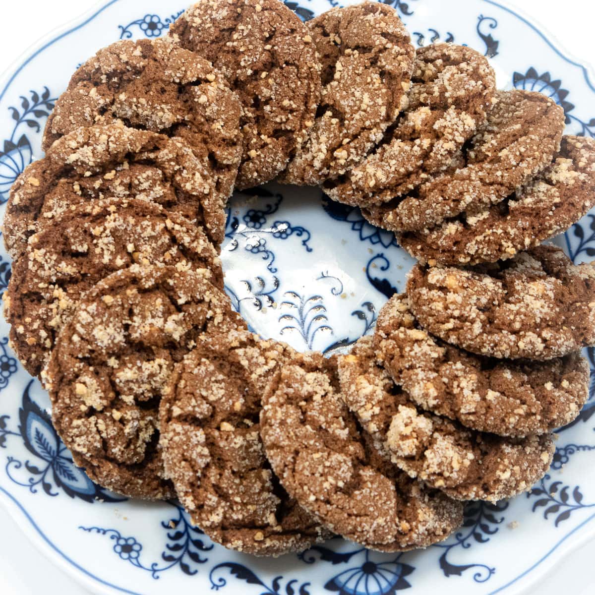 A wreath of molasses cookies sits on a blue and white plate.  