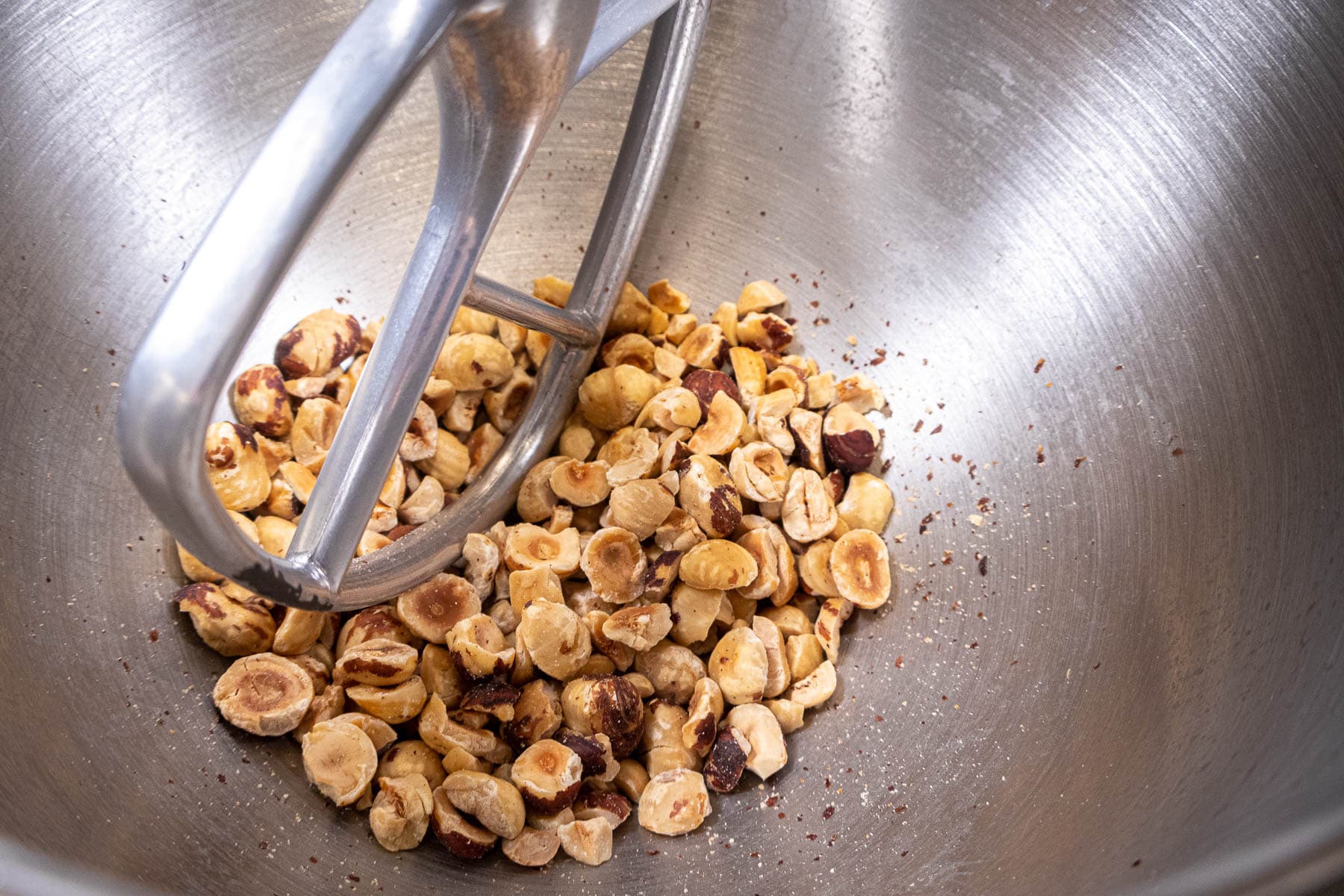 Toasted hazelnut in mixer bowl to be skinned.