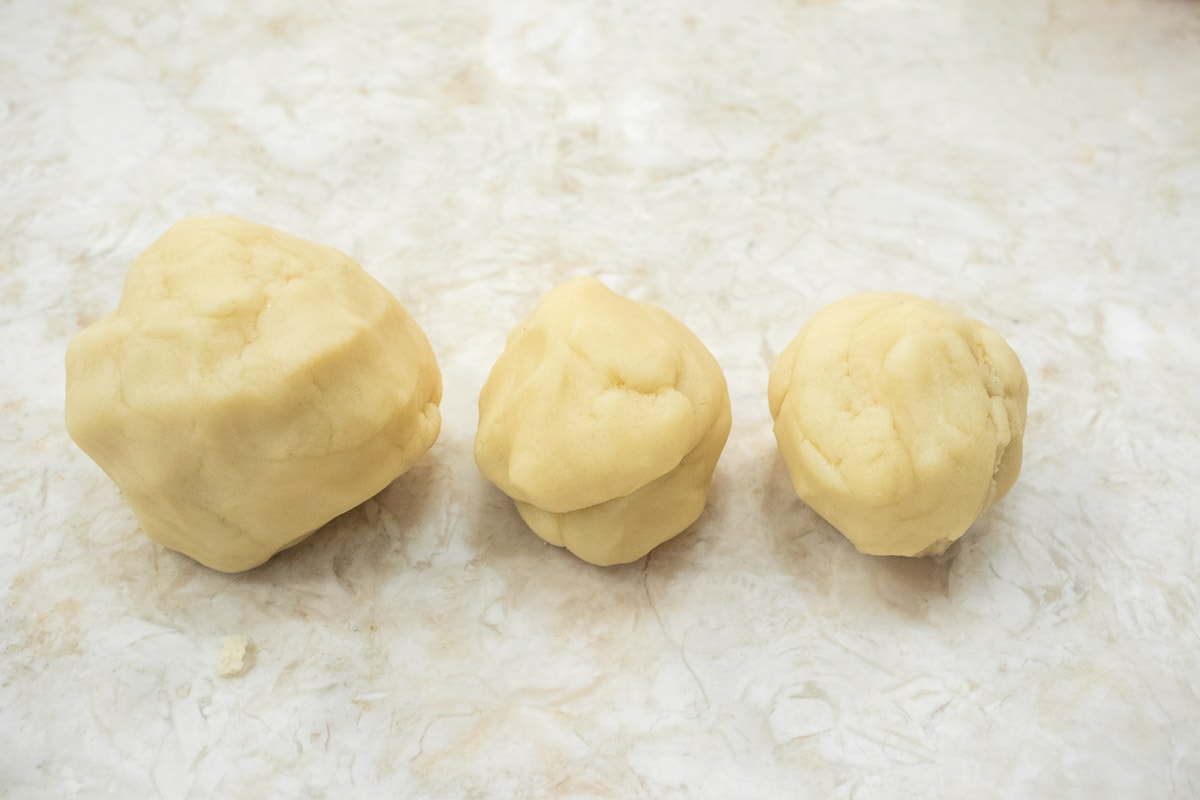The pastry dough has been divided into 3 balls for pressing in the crust of the Pate Sucree