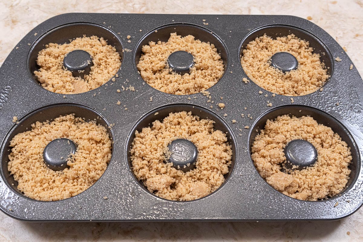 Crumbs covering the bottom of a cake donut pan.