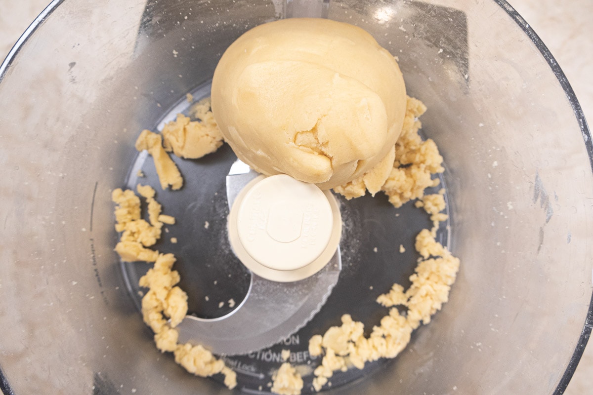 The dough is processed until it forms a ball in the processor