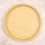 The Pâte Sucrée Crust in a tart pan with a removable bottom ready to be baked.