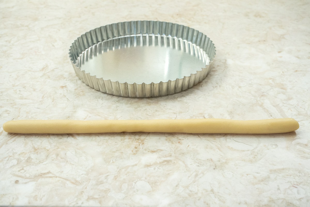 One of the smaller pieces of pastry rolled into a 14 inch rope.  The tart pan is in the background.