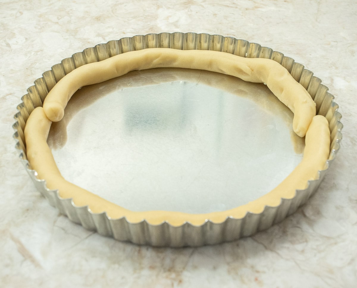 Both sides of the tart pan have been covered with the ropes of pastry with the edges overlapping about 1".
