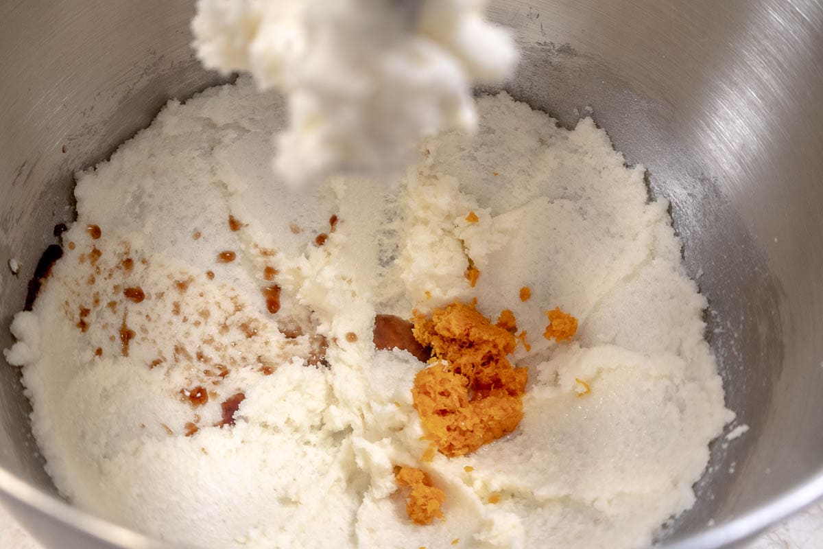 The vanilla and almond extracts as well as the orange zest is added to the creamed mixture.