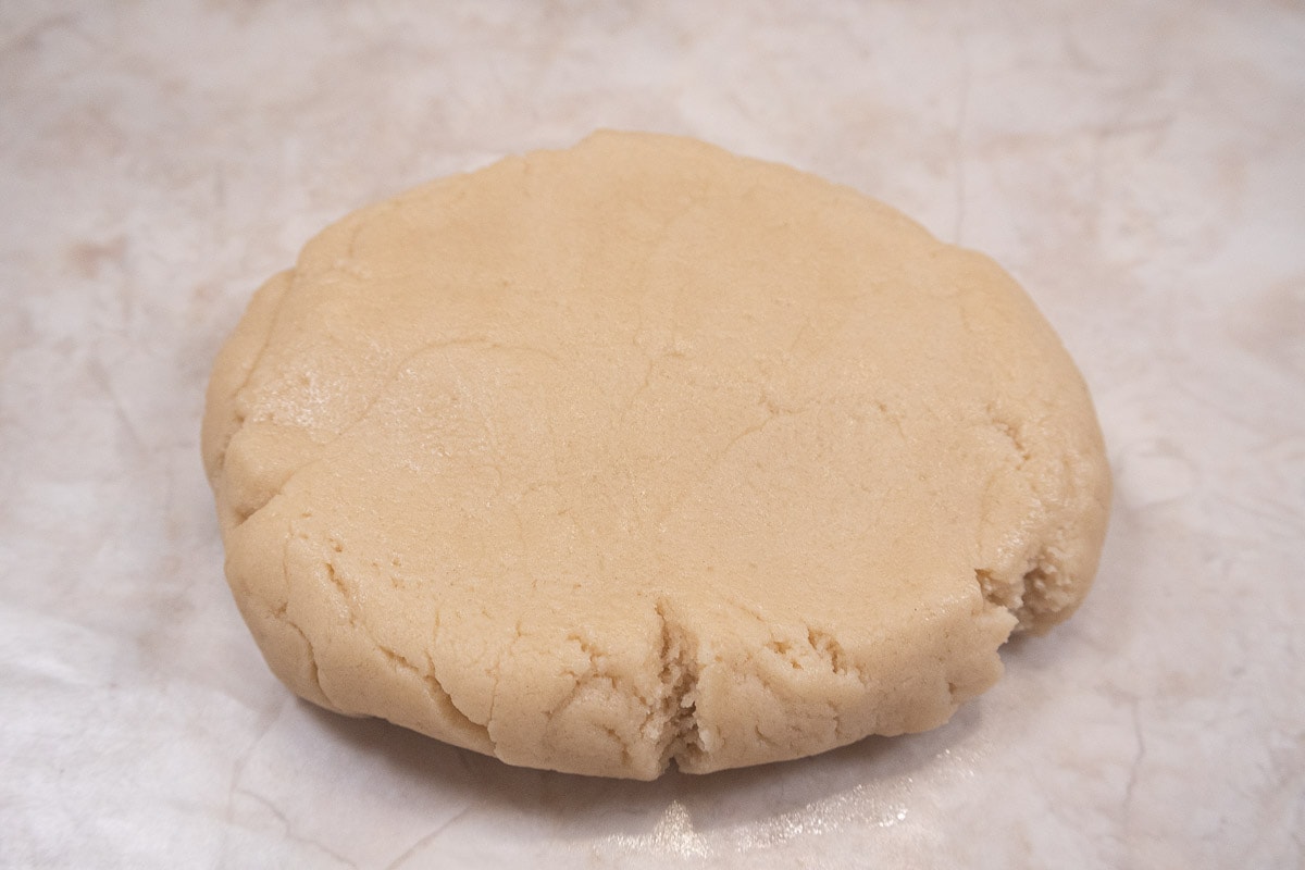 The dough is brought together and flattened into a round