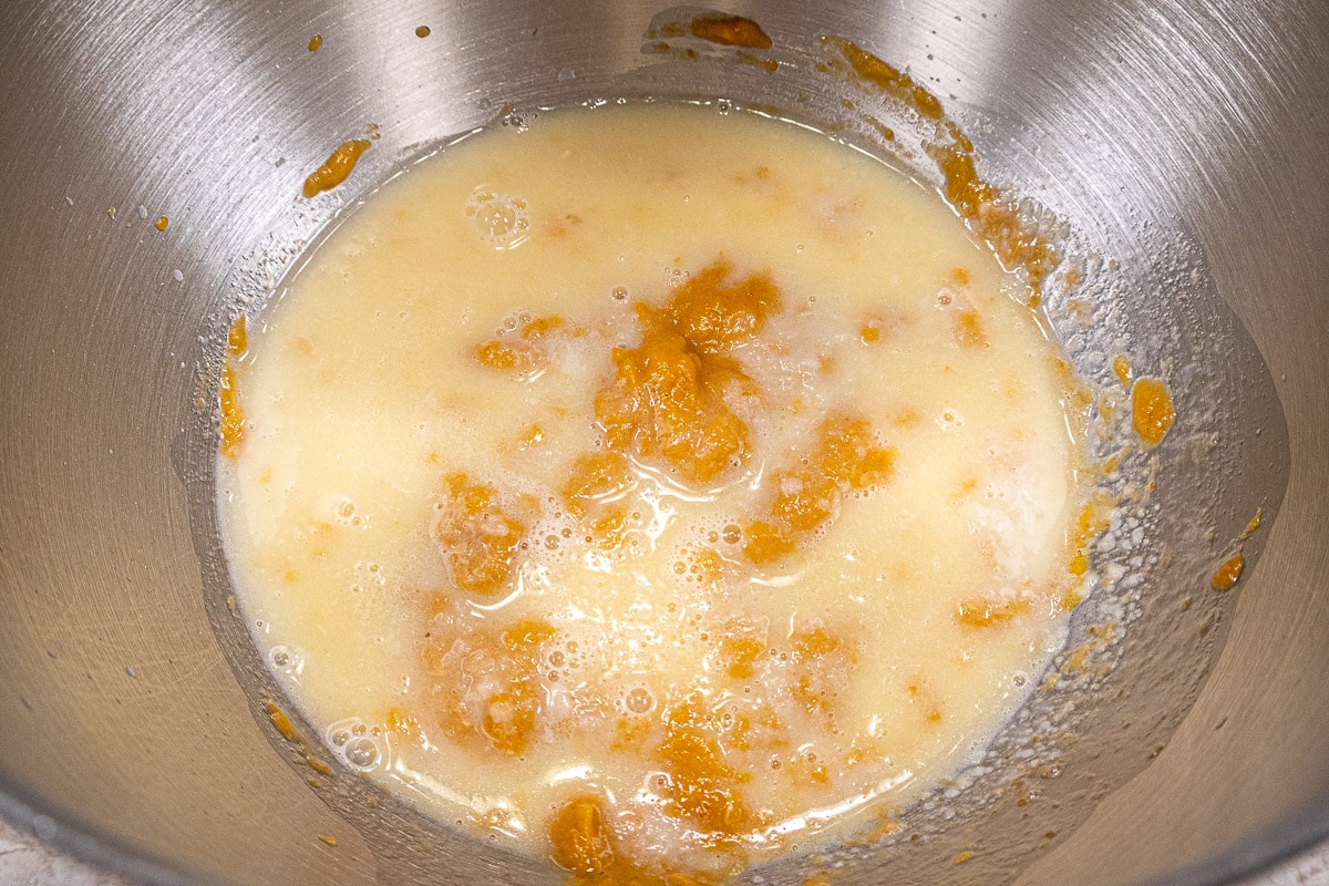 The milk, butter, honey and potato flakes are added to the egg, pumpkin and vanilla in the mixing bowl.