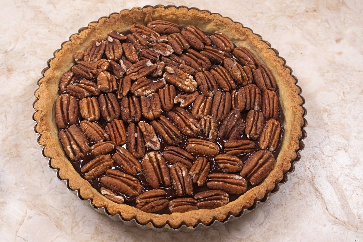 Toasted pecan halves cover the chocolate ganache