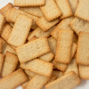 A bunch of French Butter Cookies, Petit Beurre, on a plate. They are rectangular cookies with holes throughout them and have browned edges