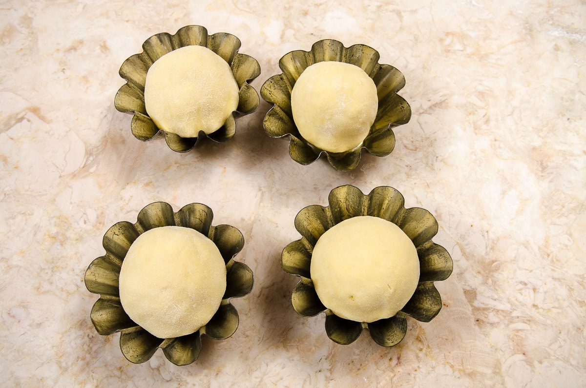 Four brioche rolls in traditional brioche molds