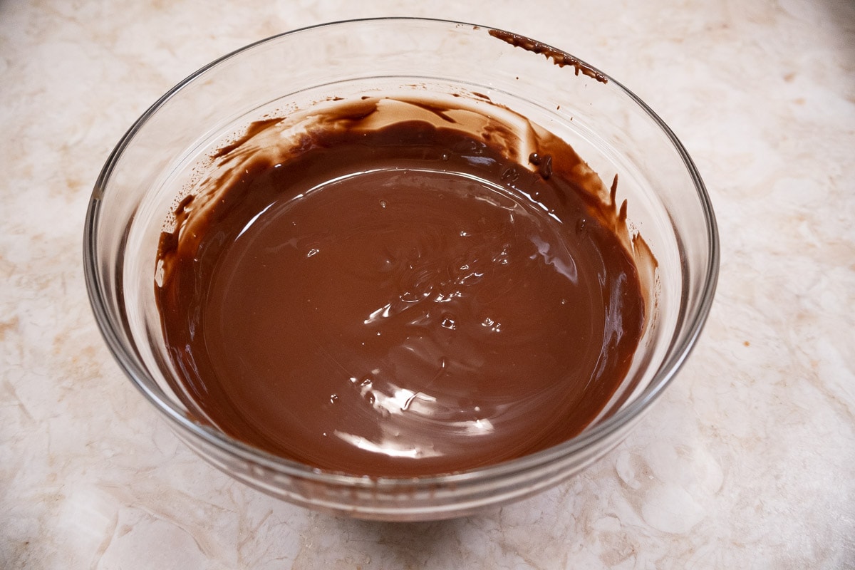 The chocolate and shortening are melted and stirred together.