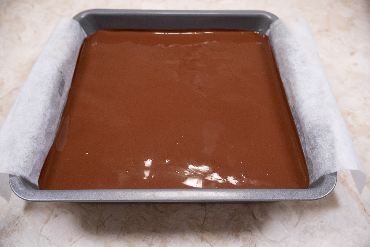 The pan is tilted from side to side and up and down to distribute the glaze evenly over the base.