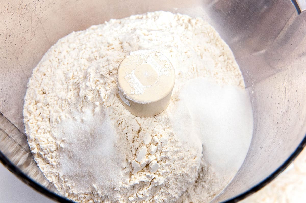 Flour, salt and sugar is added to the processor bowl.