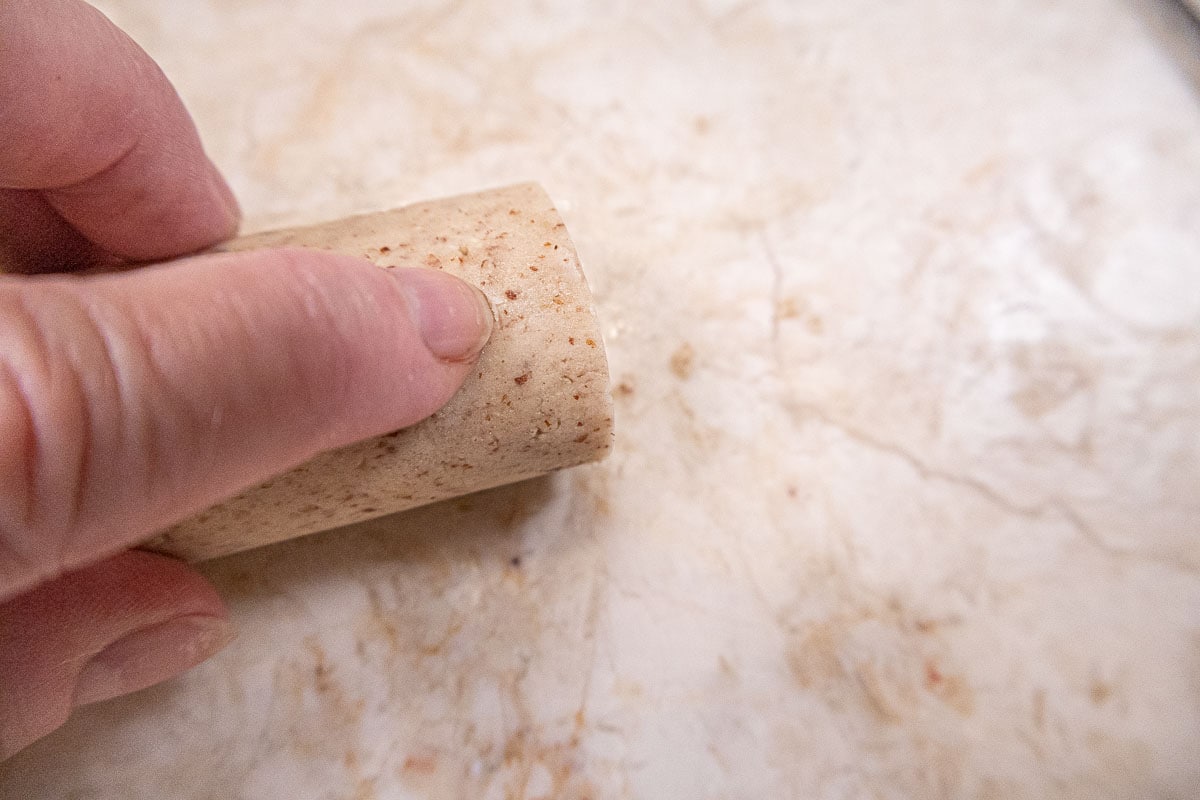 Marking the dough with  a finger.