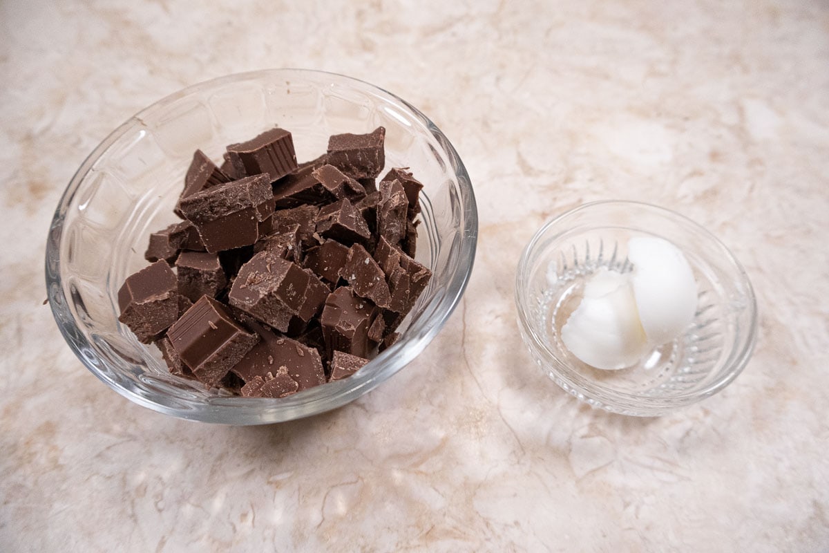 Milk chocolate in a bowl and shortening in a bowl.