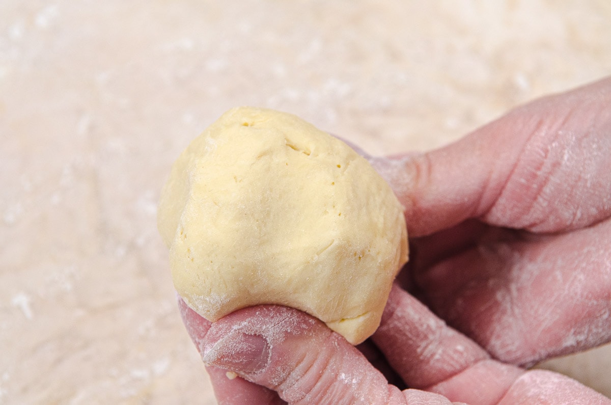 For each roll, all the sides of one piece of dough are tucked underneath to obtain a smooth ball on top