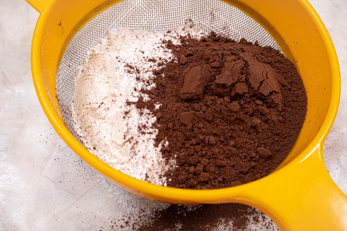 Cocoa and flour in a strainer to be sifted.