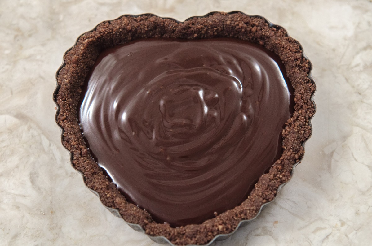 The tart shell is filled with the chocolate truffle mixture to just under the top of the crust.