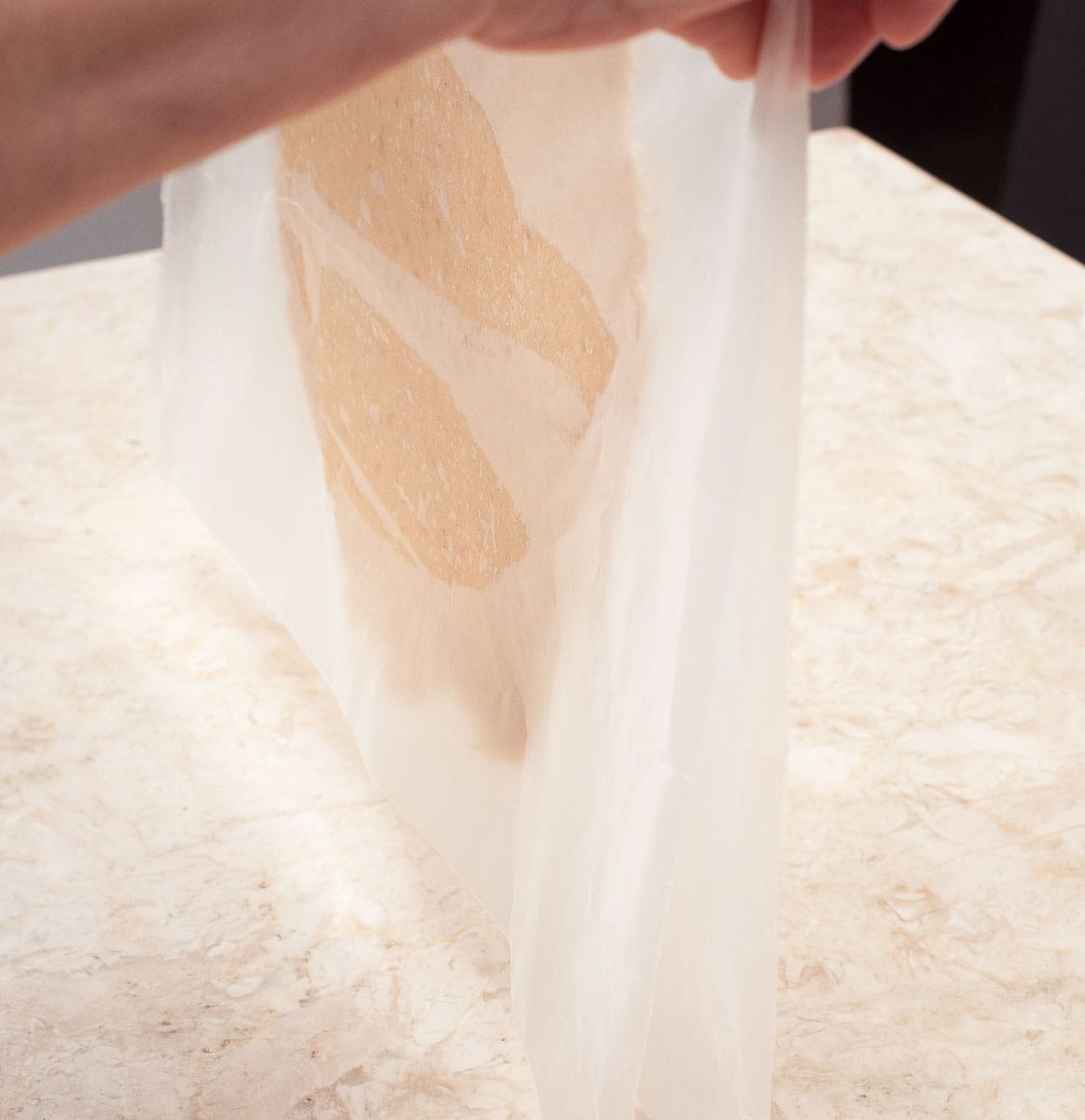 Picking up the wax paper with the dough between the paper.