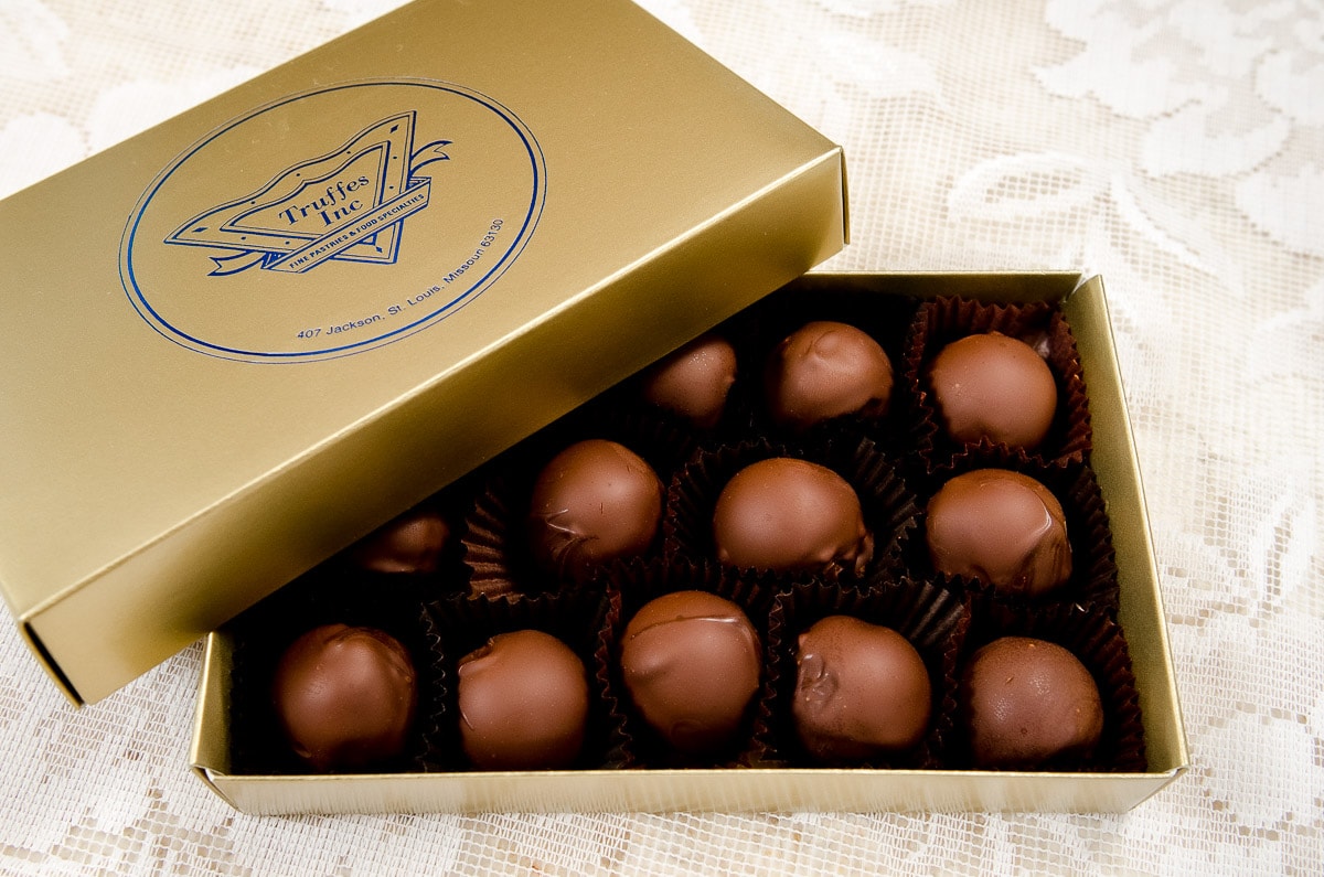 The top of a  gold box with metalic blue Truffes logo contain on top of the bottom with 15 truffles inside