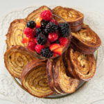 The finished French Toast arranged in a circle on a plate with the fruit and Orange Sauce in the center on top.