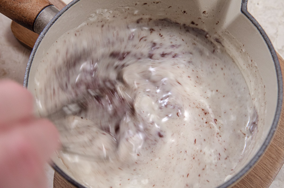 Whisking the chocolate and vanilla into the cream.