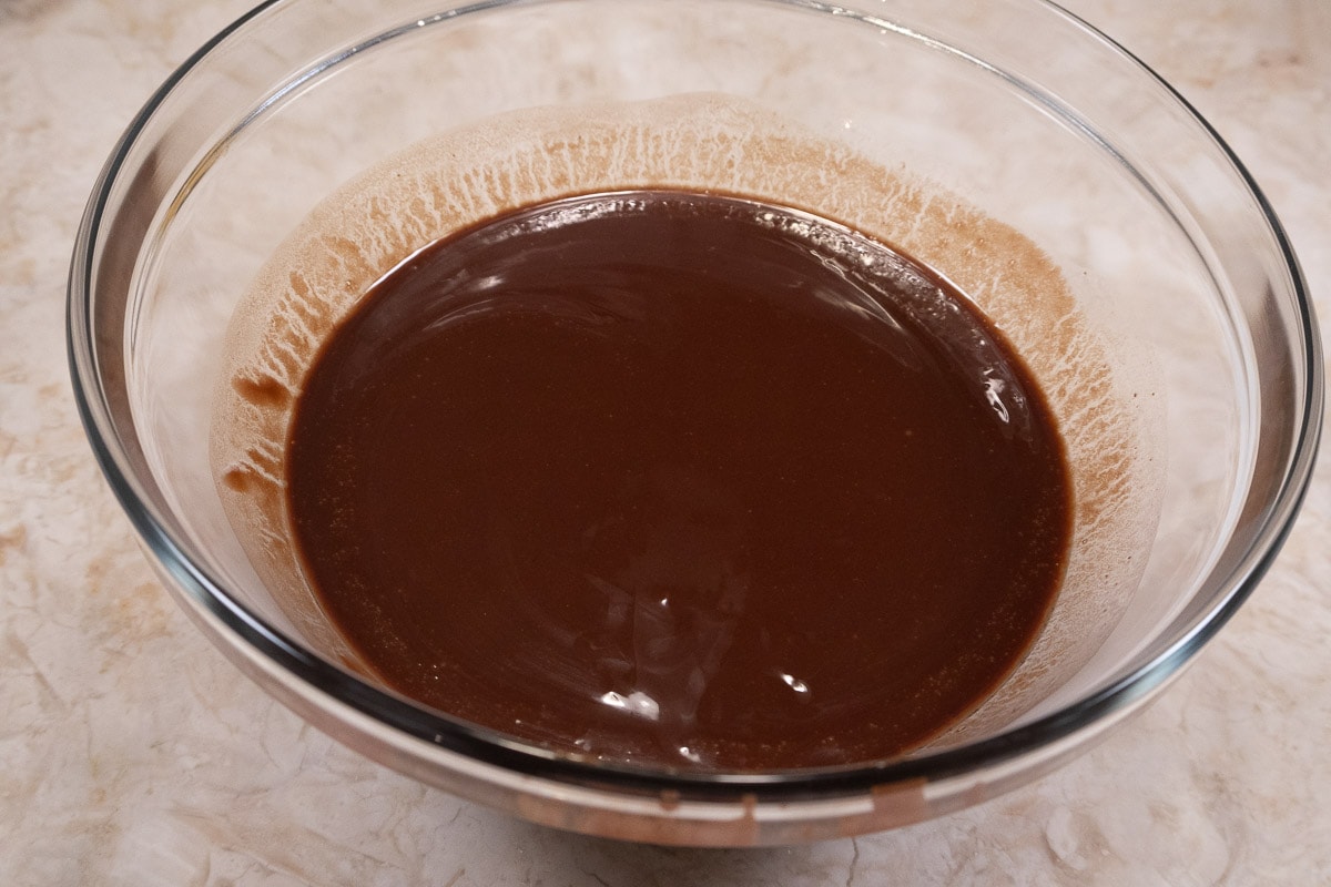 The melted chocolate and butter are whisked together to become one.  
