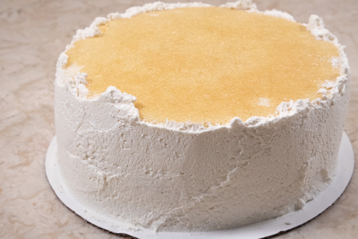 Whipped cream covering the sides of the cake.