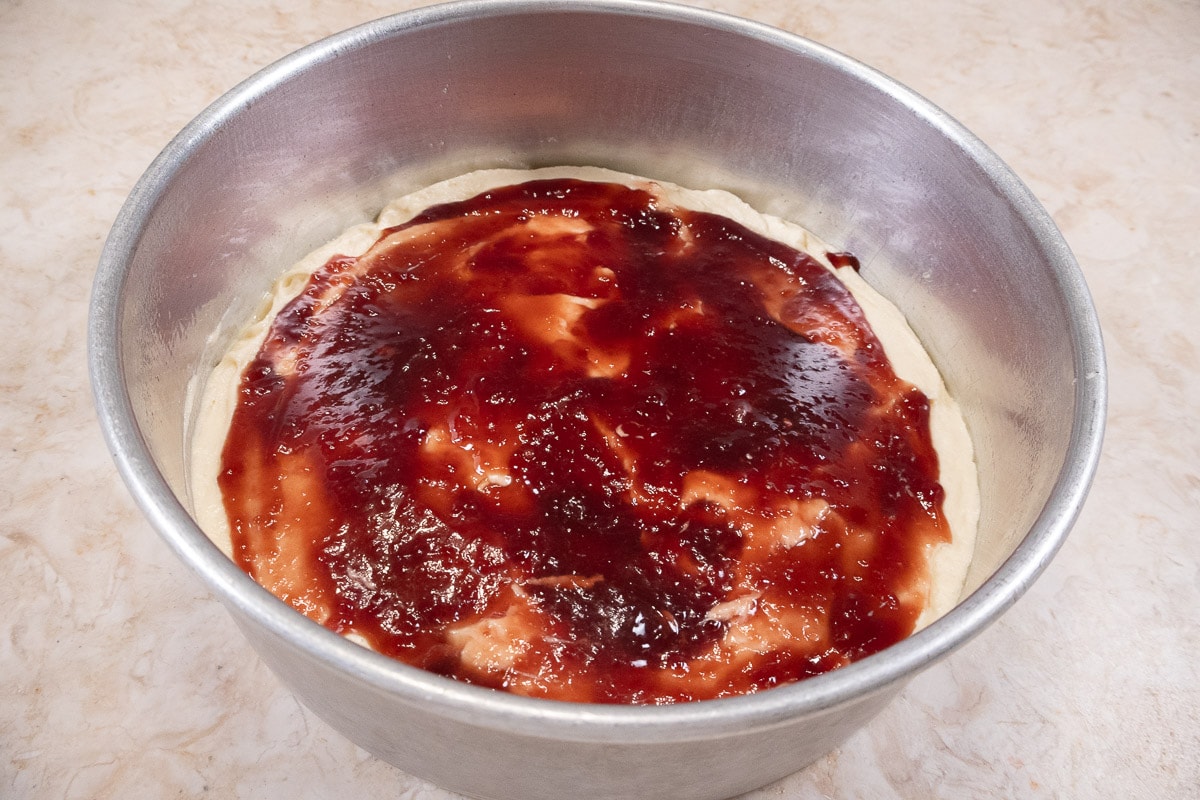 The raspberry jam is spread to about ½ inch of edges of the pan.