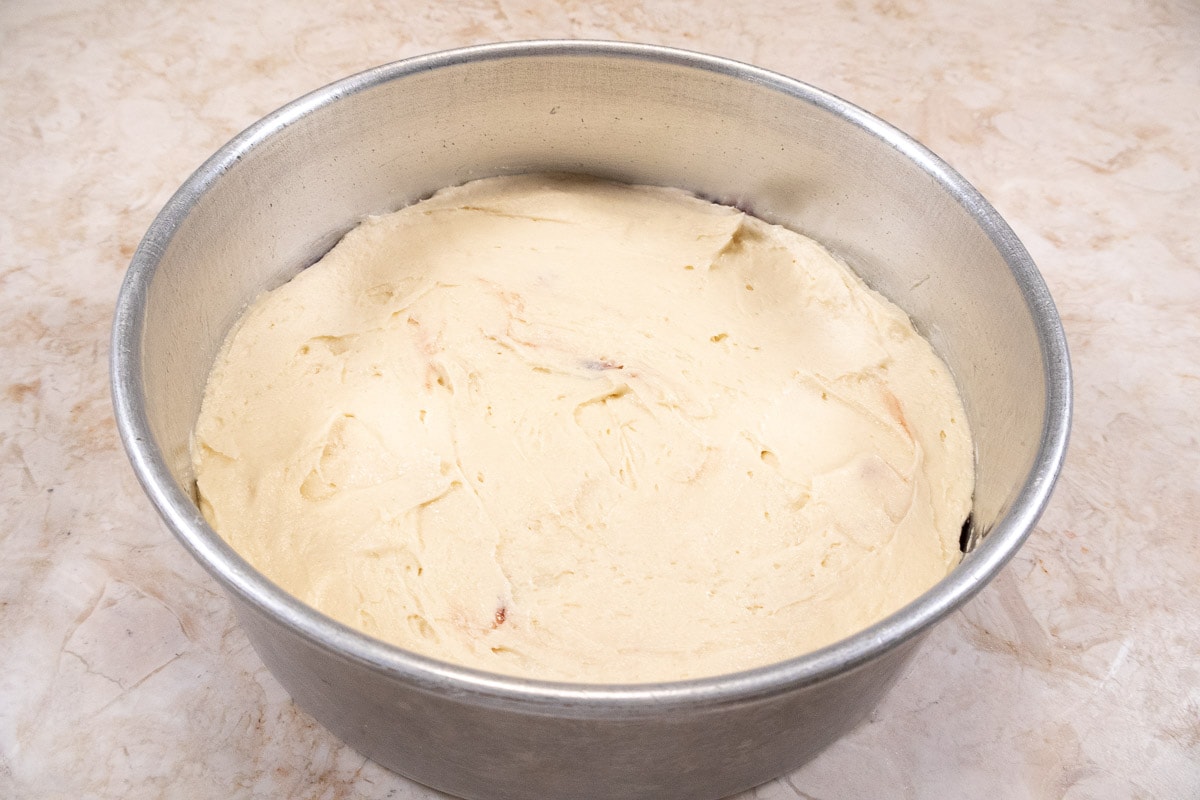 The top batter is spread smoothly over the jam layer.