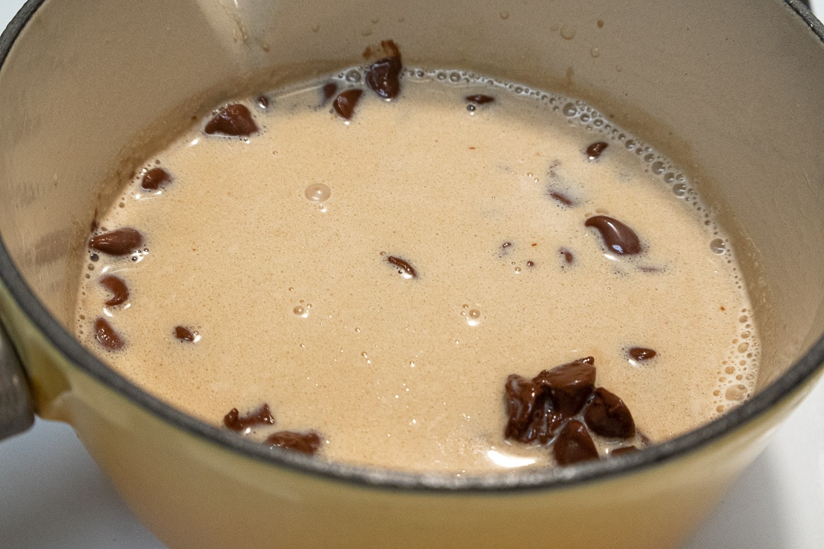 The milk chocolate chips are submerged in the hot liquid.