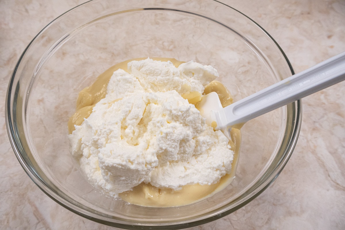 Whipped cream in bowl with pastry cream.