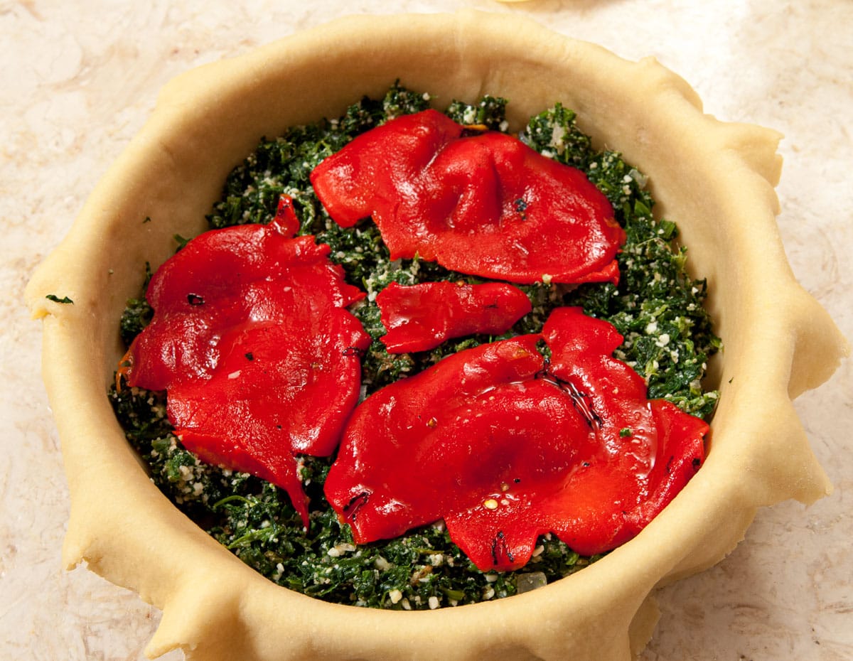 ½ the red peppers are placed over the spinach layer.