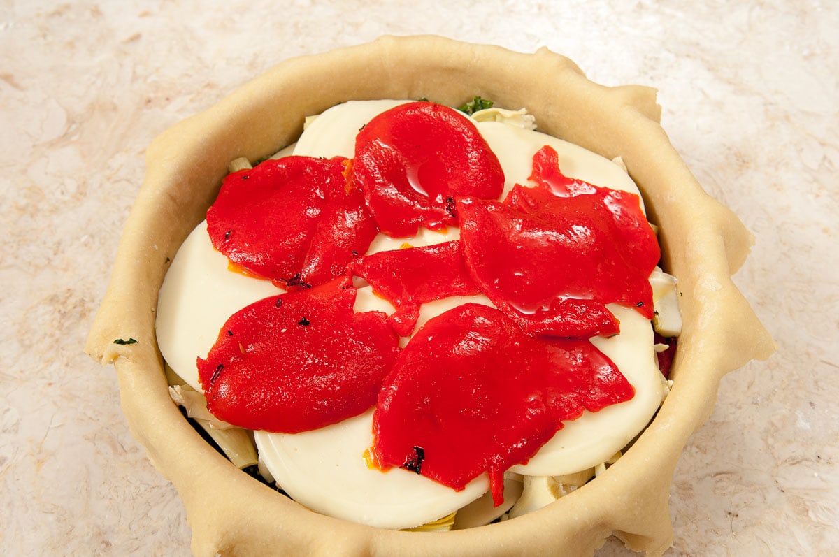 The cheese is covered with the remainder of the red peppers.