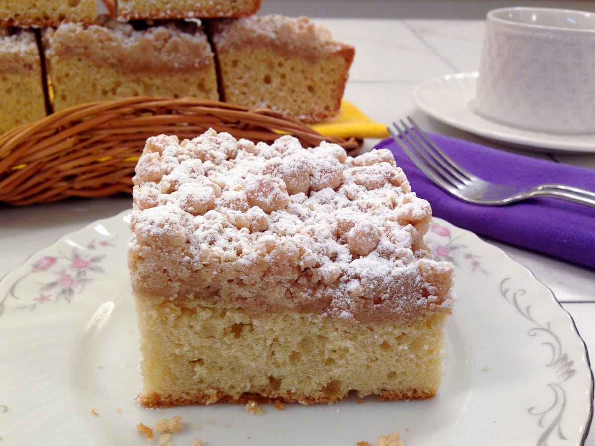 Photo of a piece of the New York Style Crumb Cake with a purple napkin.