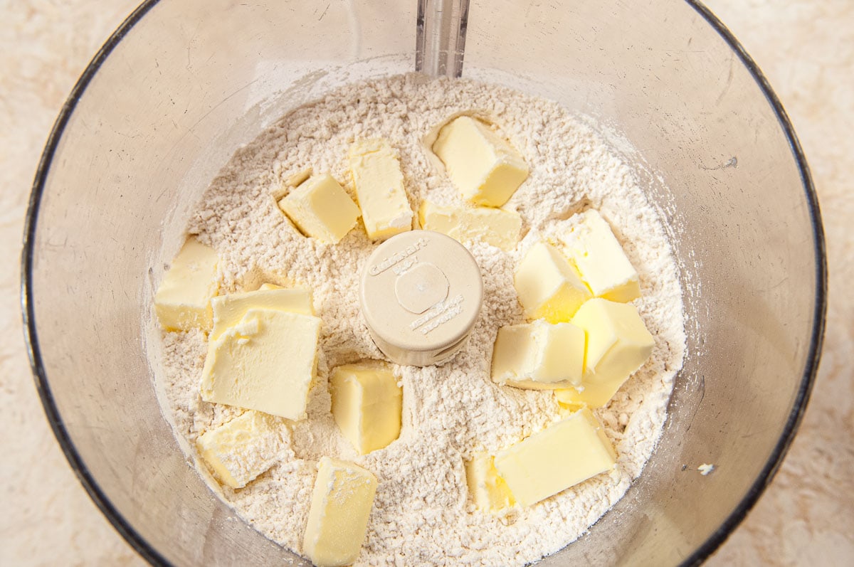 The butter for the crust has been placed over the flour.