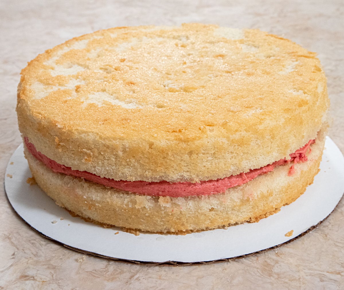 The top layer is placed, wash side down, on top of the strawberry filling.