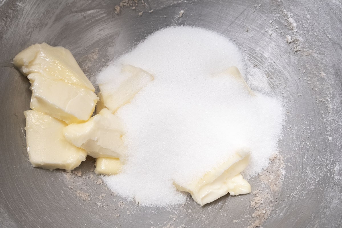 The butter and sugar in a mixing bowl to be creamed.