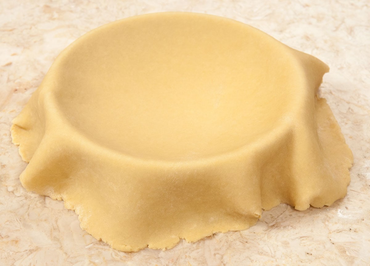 14" dough circle draped over the pan.