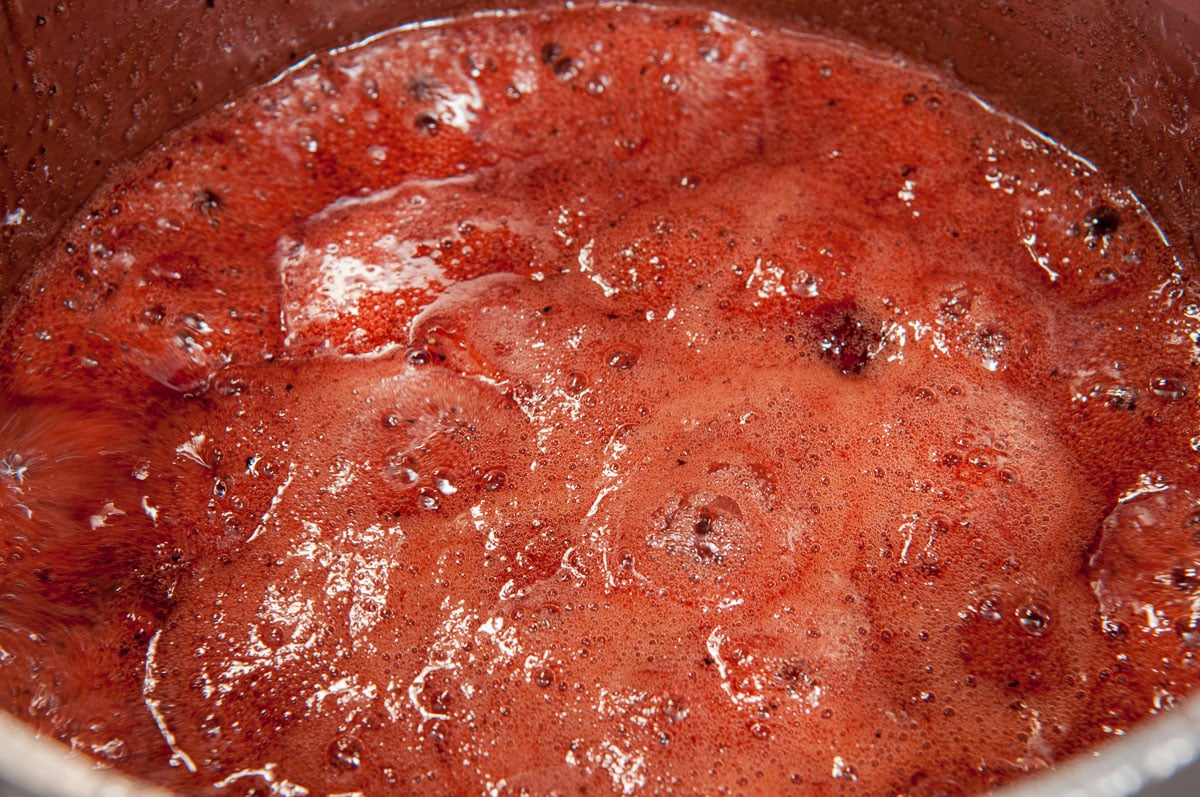 The finished jam has thick bubbles in the pan